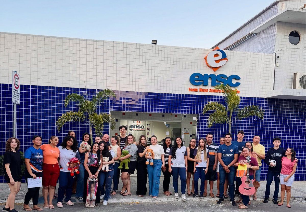 Alunos, famílias e equipe da ENSC reunidos na fachada da escola